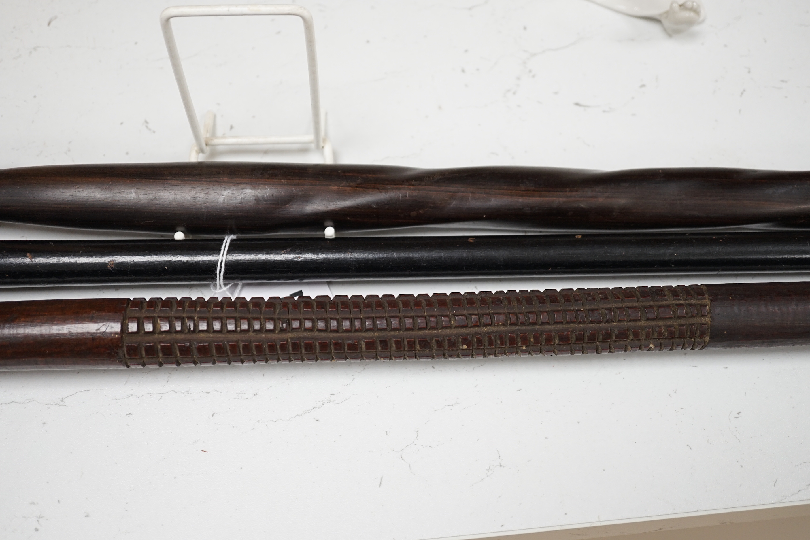 A silver topped walking cane and two African carved wood canes